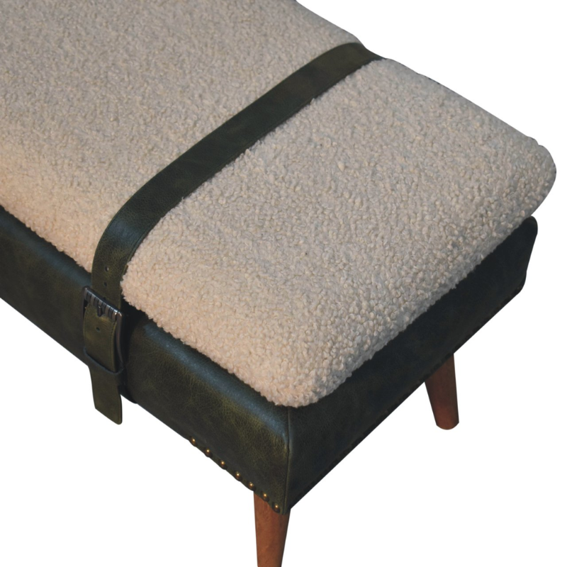 Beige cushioned ottoman with a black leather strap on a white background