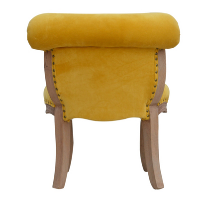 Add class and style to your home with this occasional chair. The upholstered mustard yellow cotton velvet fabric goes beautifully with the studded design giving the piece an overall unique and chic look.   With solid wooden legs constructed from 100% solid mango wood in a sunbleach finish, the chair provides strength and durability and can be incorporated in different home settings and interiors.