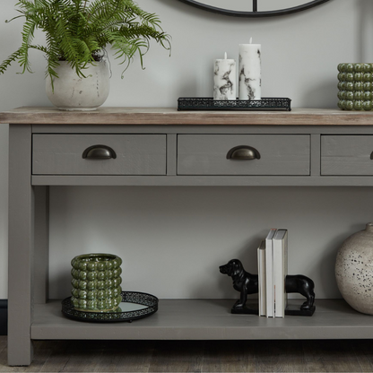 The Oxley Collection Three Drawer Console Table is perfect for display as well as storage. A washed wood plank surface blended with a frame in a warm grey hue deliver a relaxed, informal feel to any space. Stylish as well as functional, this high quality item would be equally at home in traditional and contemporary styled spaces.