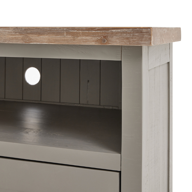 The Oxley Collection TV Unit boasts a useful drawer and shelf, circular hole to manage unsightly wires and corner-friendly shape. Its features are all designed to help keep its washed wood surface clutter free and provide the space required for modern home entertainment essentials. Stylish as well as functional, this side table would be equally at home centre stage in a room as tucked into a corner.