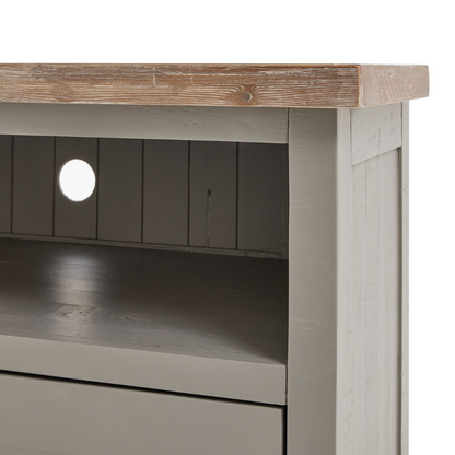 The Oxley Collection TV Unit boasts a useful drawer and shelf, circular hole to manage unsightly wires and corner-friendly shape. Its features are all designed to help keep its washed wood surface clutter free and provide the space required for modern home entertainment essentials. Stylish as well as functional, this side table would be equally at home centre stage in a room as tucked into a corner.