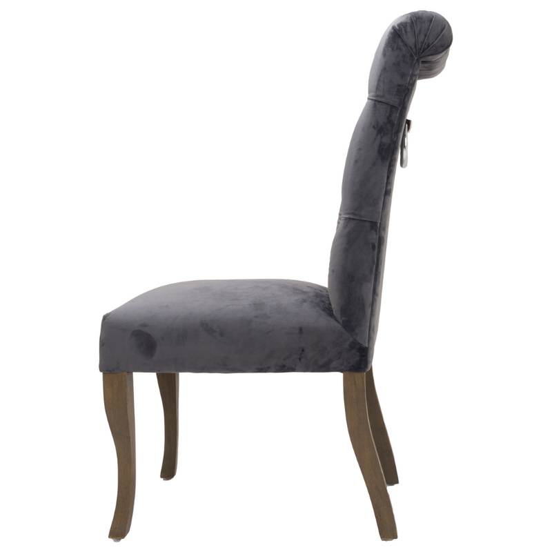 This is the Knightsbridge Roll Top Dining Chair. A sumptuous button pressed velvet chair in a timeless great colour with roll-top detail and silver ring pull that will add elegance and class to a variety of interiors. Built from a rubberwood frame, known for its dense grain and strength, it is a sturdy piece, ready for everyday use. All upholstered items have passed UK fire safety regulations with cigarette and match test certificates.