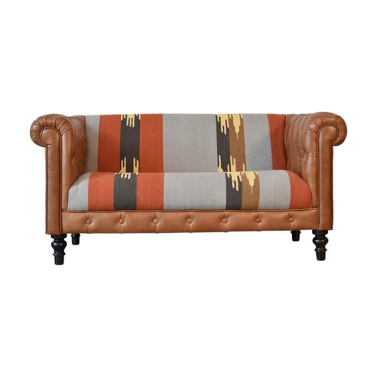 Introduce a playful piece to your interiors with this mixed sofa.  Combining both buffalo leather and durrie prints, it has 4 turned legs in a dark walnut finish and it is the perfect piece to use in the living room to seat family and friends for a comfortable experience when you just want to kick back and relax.