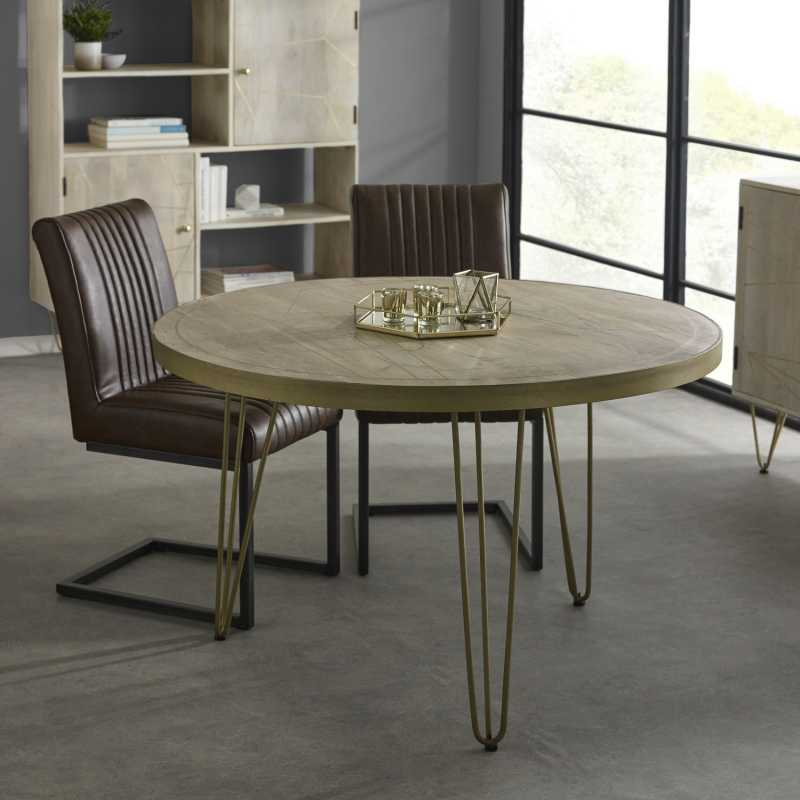 This elegant round dining table will add a touch of style to your dining room, while comfortably seating 4 people.  The table top is stained in a light natural finish, featuring gold metal inlays and a matching frame on the edge of the table top, complemented by gold metal legs.